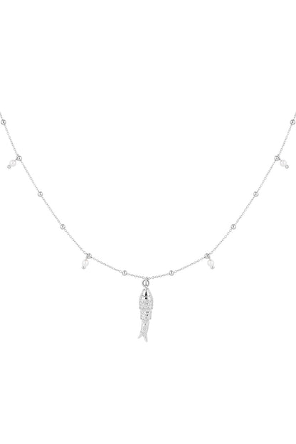 Close-up of delicate silver fish charm necklace with tiny pearl-like beads on a white background