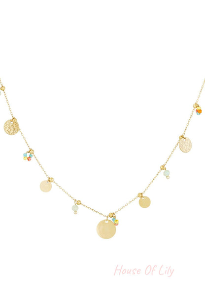 Close-up of delicate gold disc charm necklace with small colourful and pastel beads on thin gold chain