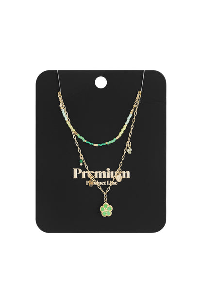 Packaged double-layered necklace displayed against a black card with gold text, showing green beads and flower pendant