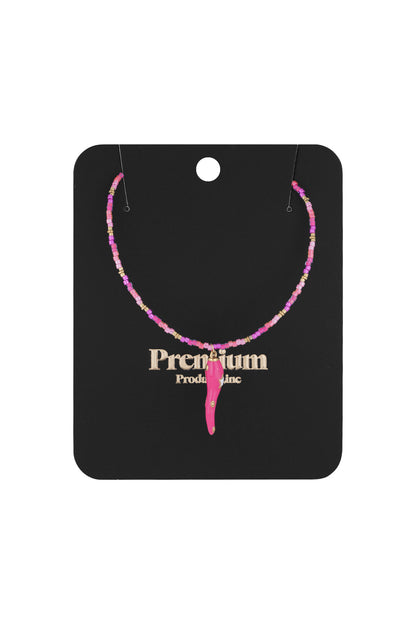 Pink and gold beaded choker necklace with chili pepper pendant displayed on black premium packaging card