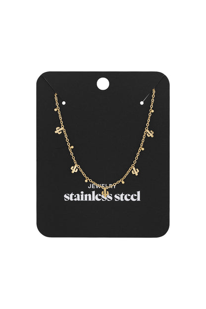 Gold cactus charm necklace displayed on black stainless steel branded card