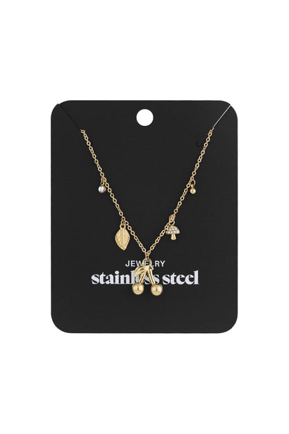 Gold charm necklace displayed on a black jewelry card reading 'stainless steel' with cherry, leaf, mushroom pendants
