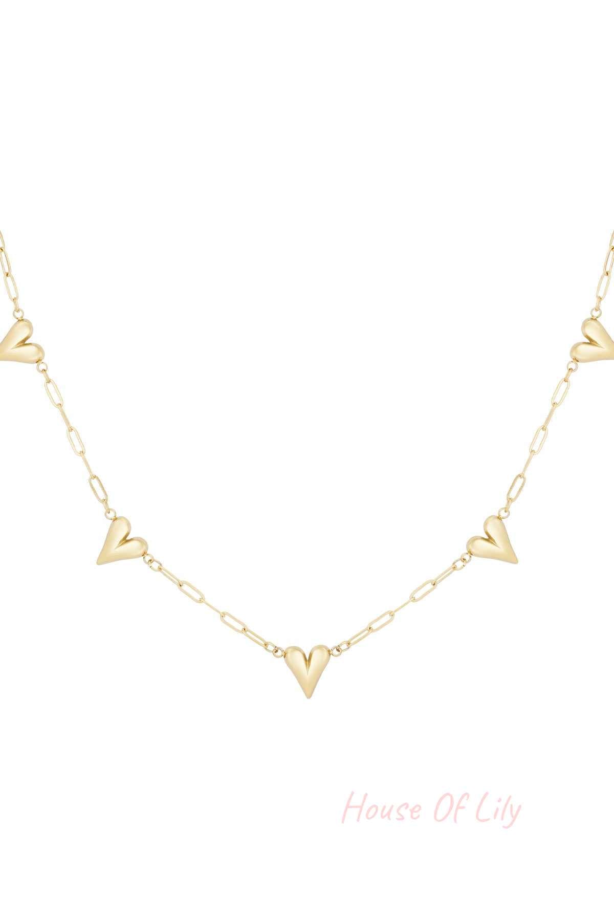 Close-up of a delicate gold-tone chain necklace with multiple small hollow heart charms evenly spaced on a white background