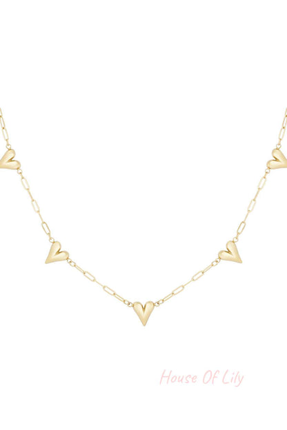 Close-up of a delicate gold-tone chain necklace with multiple small hollow heart charms evenly spaced on a white background