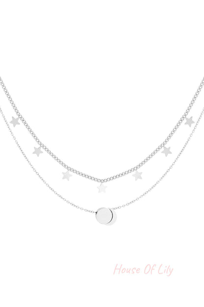 Silver layered necklace with star charms and round pendant on white background