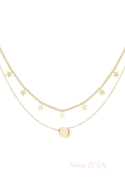 Gold layered necklace with star charms and round pendant on white background
