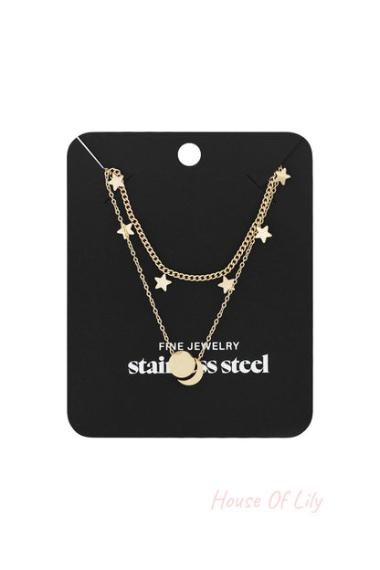 Gold layered star charm necklace with round pendant displayed on black jewelry card with stainless steel label