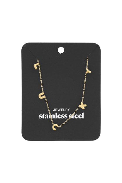 Gold LUCKY letter pendant necklace displayed on black stainless steel jewelry card