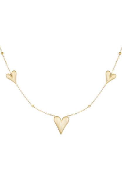 Gold necklace with three heart-shaped charms and small bead accents on a fine chain