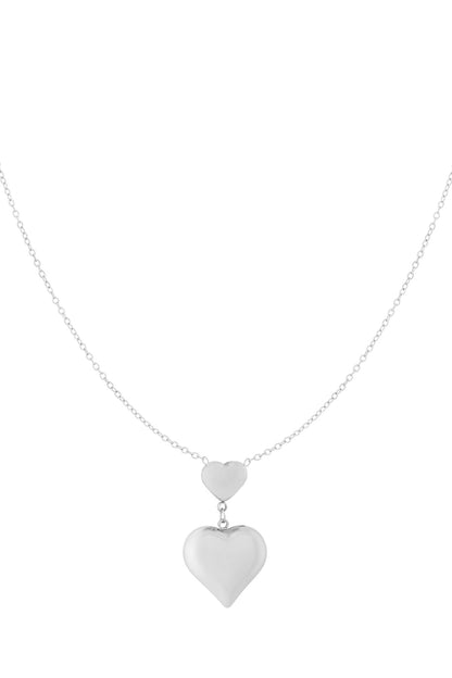 Silver double heart pendant necklace featuring the same design with two connected hearts on a fine chain, white background