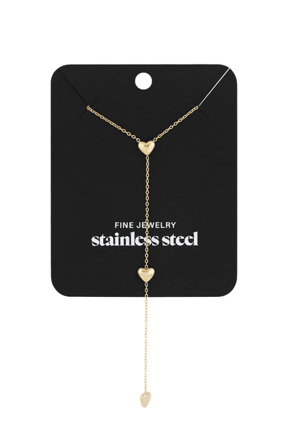 Gold heart drop necklace displayed on black card labelled stainless steel fine jewelry
