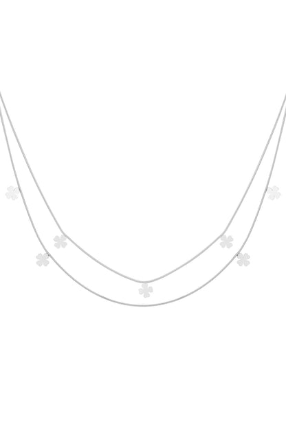 Double-layer silver necklace featuring multiple small four-leaf clover charms on delicate chains laid flat