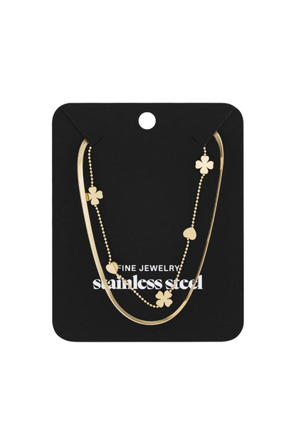 Gold layered necklace with hearts and clovers displayed on black jewelry card labeled stainless steel fine jewelry