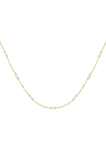 Close-up of delicate gold chain necklace adorned with evenly spaced rectangular clear crystals on white background