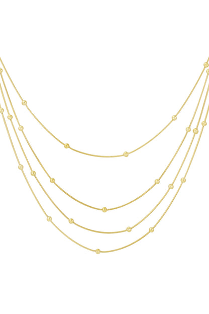 Close-up of gold layered necklace with evenly spaced beads on thin chains