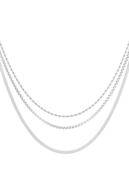 Three silver-tone layered chain necklaces display with distinct styles