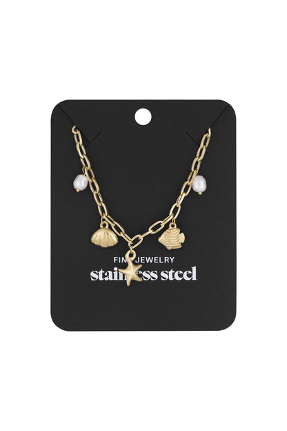 Gold beach charm pendant necklace displayed on black retail card with stainless steel branding
