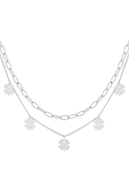 Silver layered necklace with clover charms shown against white background