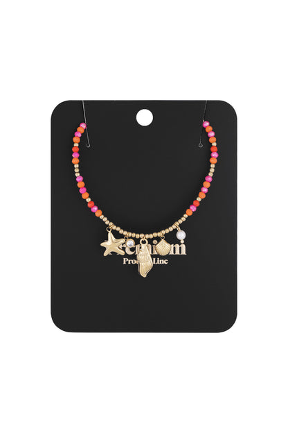 Necklace displayed on black packaging card showing the colorful beads and ocean-inspired gold charms