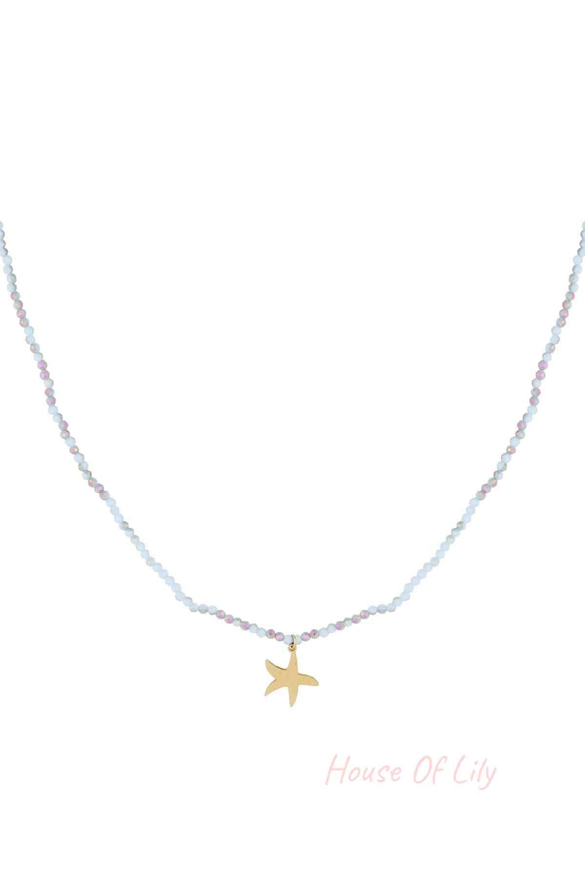 Close-up of a delicate beaded necklace with light blue and iridescent beads and a gold starfish charm pendant on white background