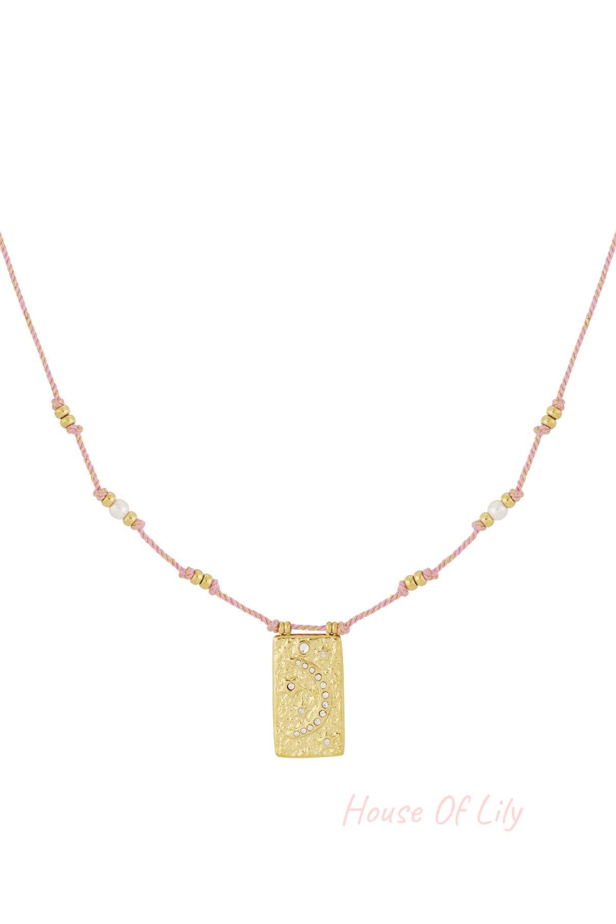 Close-up of a pink braided necklace with gold-tone moon pendant and crystal accents