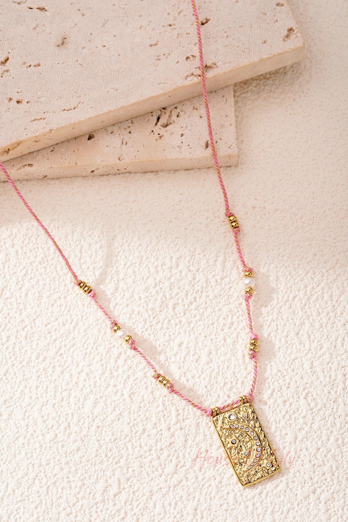 Close detailed photo of pink braided moon pendant necklace showing crystal embellishments
