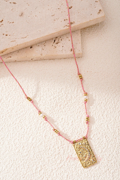 Close detailed photo of pink braided moon pendant necklace showing crystal embellishments