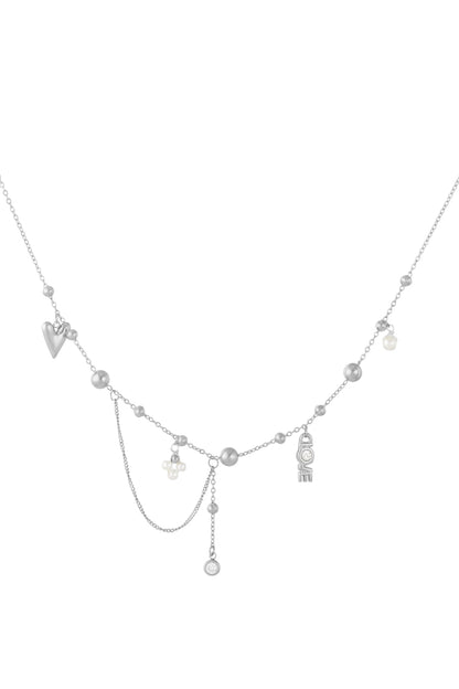 Silver tone pendant necklace laid flat highlighting fine chain, small silver beads, pearls, LOVE letter charm, and dangling crystal pendant