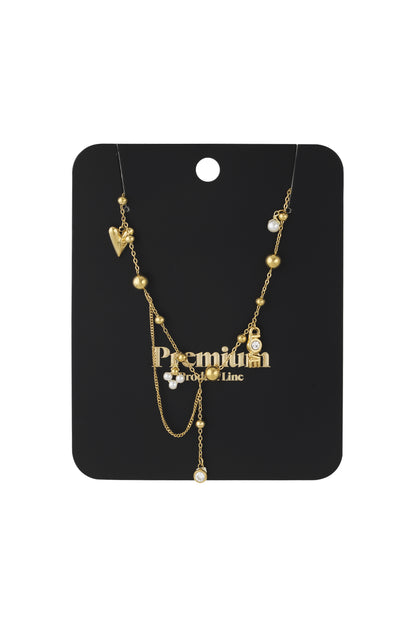 Gold pendant necklace displayed on black packaging card with 'Premium' branding
