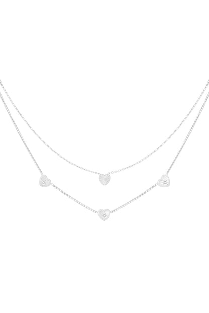 Silver-tone version of the double layered heart necklace with small rhinestone accents on white background