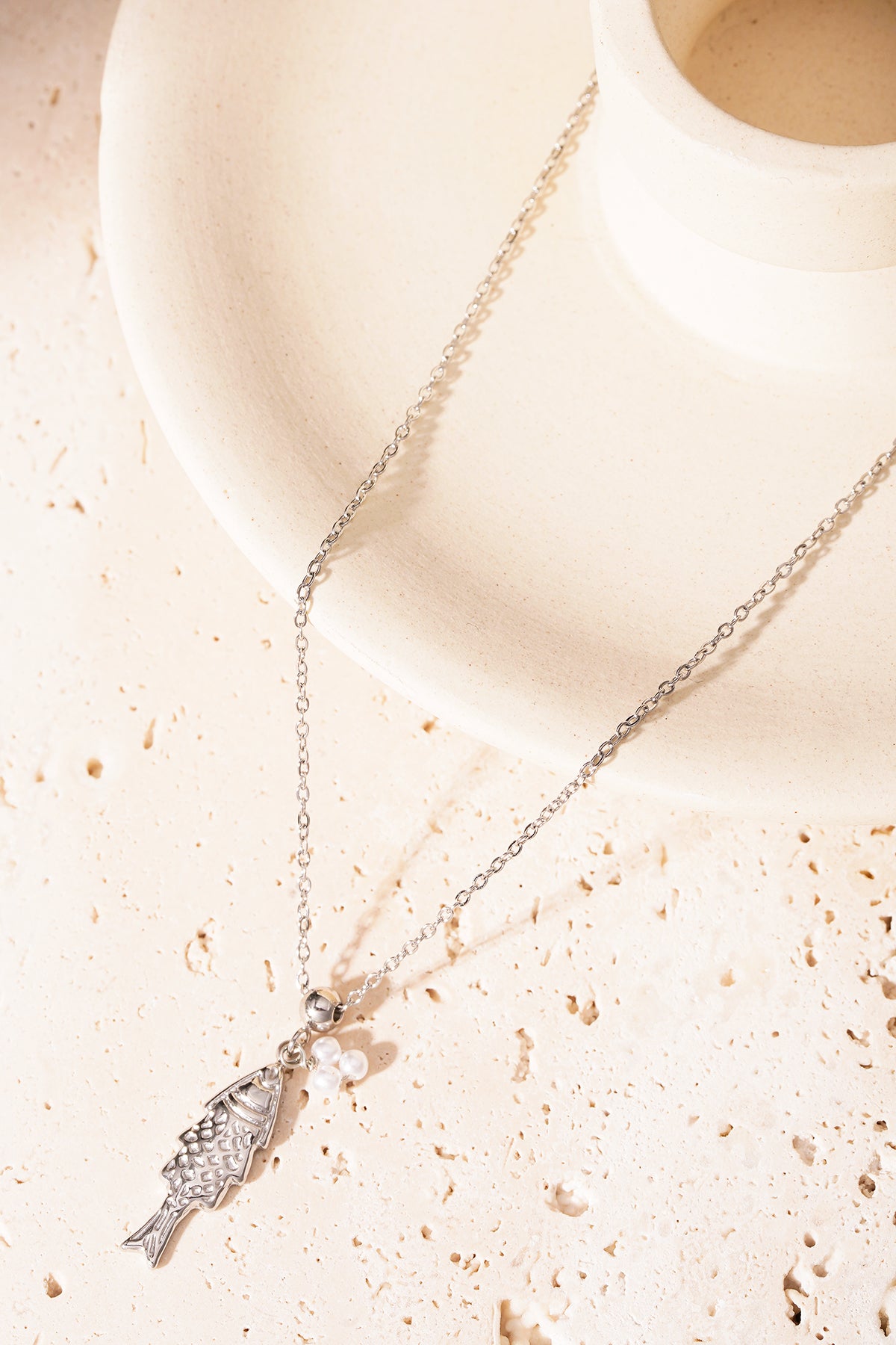 Silver fish pendant necklace on black Premium Product Line card