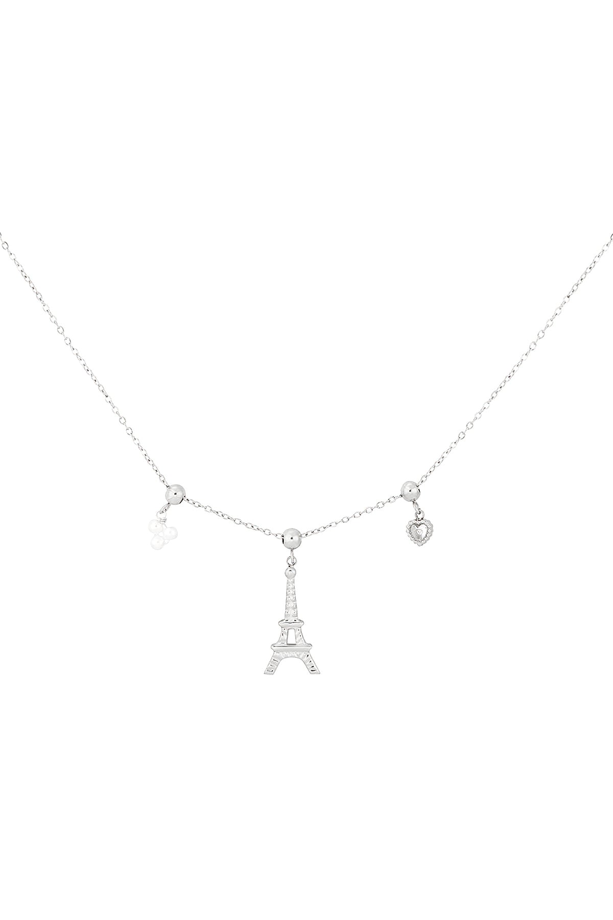 Silver-tone charm necklace featuring an Eiffel Tower centerpiece flanked by small heart and flower charms on a fine chain.