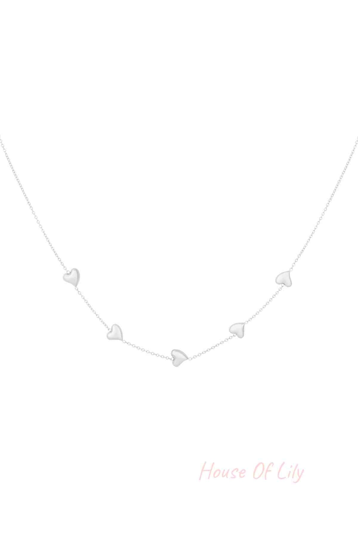Silver dainty necklace with five small heart-shaped charms evenly spaced on a fine chain, isolated on white background