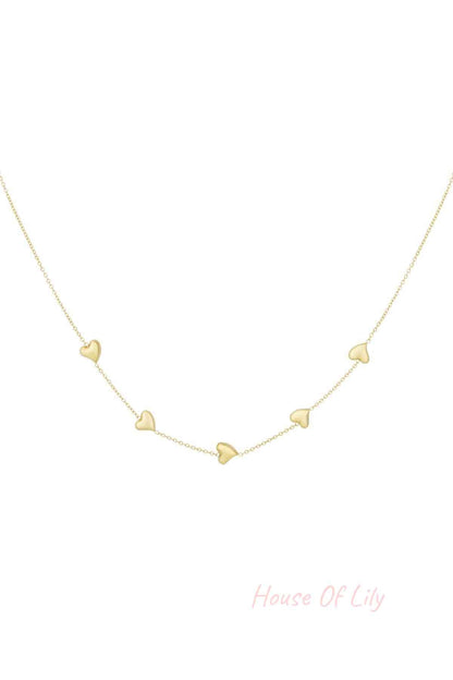 Gold dainty necklace with five small heart-shaped charms evenly spaced on a fine chain, isolated on white background