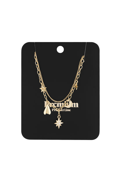 Gold layered celestial charm necklace displayed on a black jewelry card