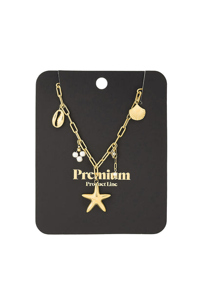 Gold seaside charm necklace attached to a black jewellery card reading Premium Product Line