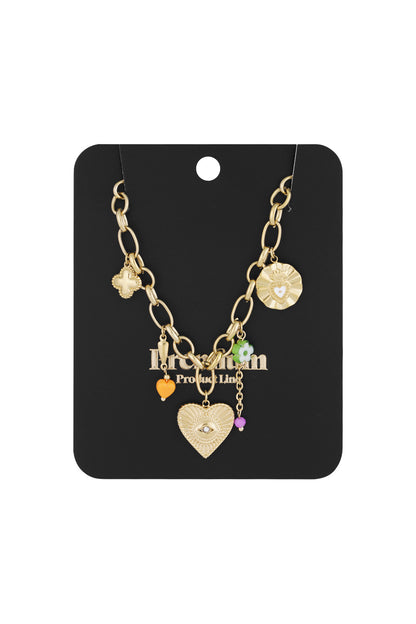 Gold-tone charm necklace displayed on black card packaging, showing detailed charms including a heart with an eye motif and colourful beads