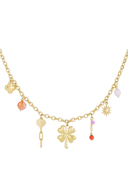 Gold-tone chain necklace with charms including a four leaf clover, heart, sun, and coloured beads on a white background
