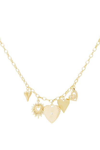Close-up image of a gold link necklace with five heart and sunburst-shaped charms on a white background