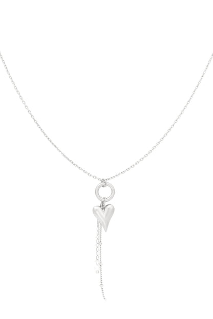Silver heart charm pendant necklace with dangling chain and faux pearl detail on white background