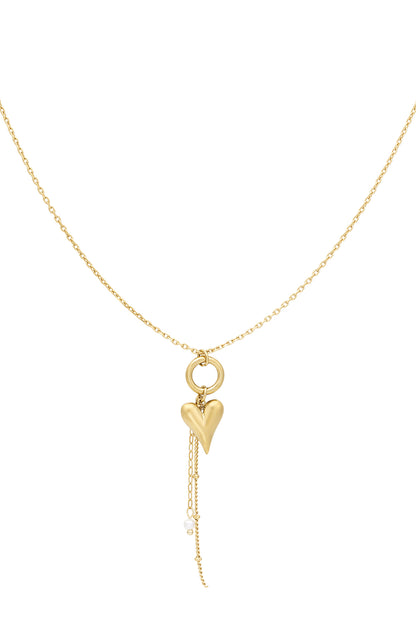Gold heart charm pendant necklace with dangling chain and faux pearl detail on white background