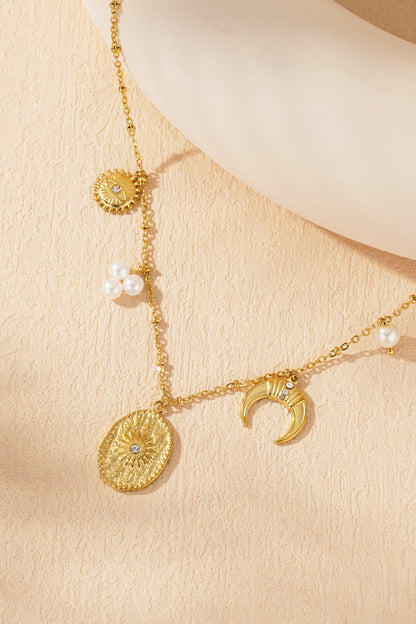 Close-up of gold-tone celestial charm necklace pendant cluster featuring textured sun medallion and crescent moon with crystals