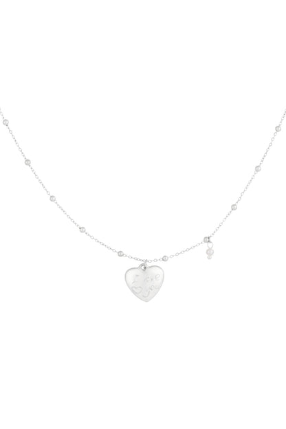 Silver heart charm pendant necklace with bead chain and small pearl accent on white background