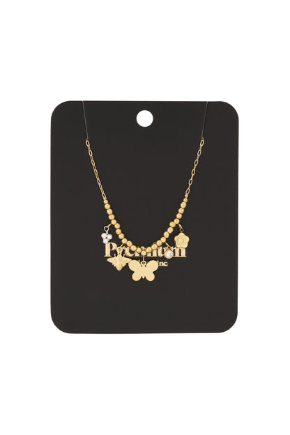 Gold charm beaded necklace displayed on black branded packaging card