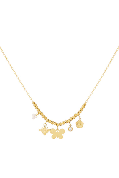 Close-up of gold beaded charm necklace with butterfly, bee, pearl cluster, crystal and flower charms on white background