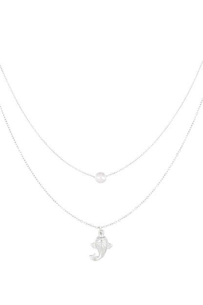 Silver layered necklace with a pearl and fish charm on white background