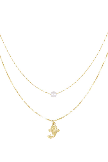 Gold layered necklace showing one chain with single pearl and another with fish pendant on white background