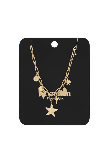 Gold charm necklace displayed on a black branded card holder showing the beach-inspired charms clearly