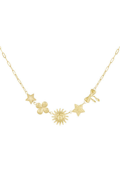 Gold-tone celestial charm necklace with star, clover, sun, textured star, and bow charms laid flat on white background
