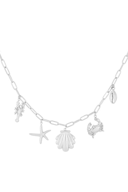 Silver chain necklace with seaside-themed charms including lobster, starfish, scallop shell, crab, and cowrie shell on white background